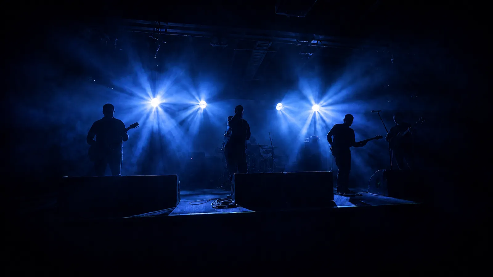 Parhelion performing live, the band in silhouette against blue stage light